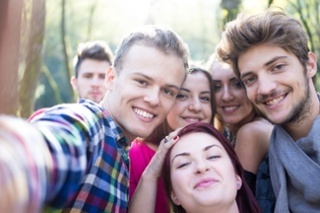Young people having good time together in park on river and taking selfie.jpeg